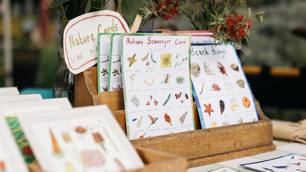 A close up photo of a market stall display featuring illustrated paper products