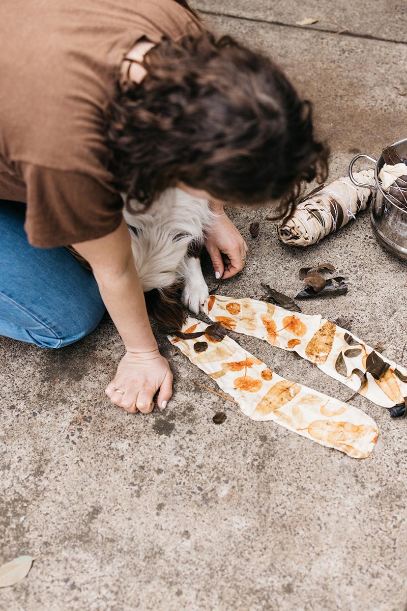 An image of a woman and her dog demonstrating the eco-dye clothing process on a pair of socks