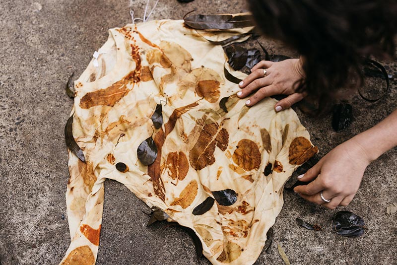 A close-up of a person using eco-dye techniques to decorate clothing